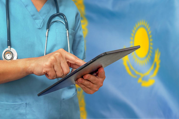 Хирург или врач с помощью цифровой таблетки на фоне казахстанского флага. Медицинское оборудование или медицинская сеть, технологии и диагностика в Казахстане
. - Фото, изображение