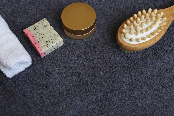 casa de spa. cepillo de masaje, jabón y crema sobre un fondo de toalla gris
 - Foto, Imagen