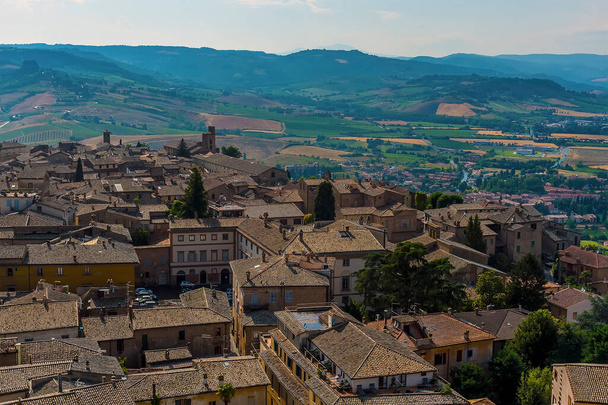 The roof tops of Orvieto, Italy rise above the surrounding countryside in summer - Foto, afbeelding