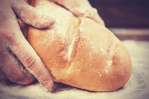 Les mains de Baker avec un pain
. - Photo, image