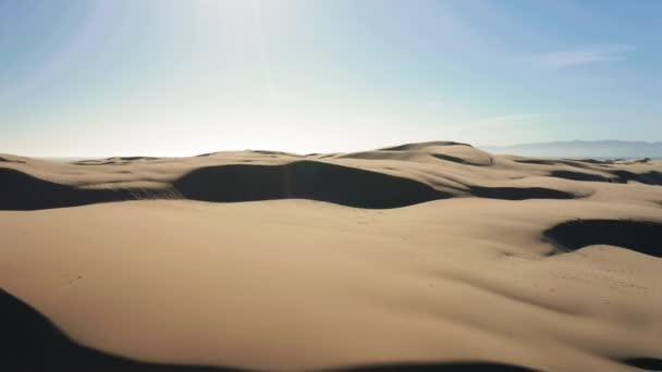 4K-Drohnenbild, das durch wunderschöne wellige Sanddünen in goldenem Sonnenuntergang fliegt - Filmmaterial, Video