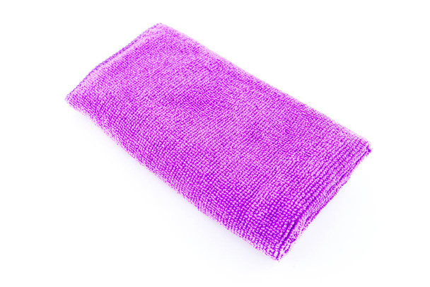 Tejido de microfibra púrpura yaciendo en el medio, aislado sobre un fondo blanco, vista superior
. - Foto, Imagen