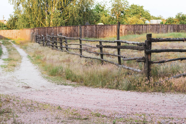 Скот пасущийся деревянный забор на повороте сельской дороги
 - Фото, изображение