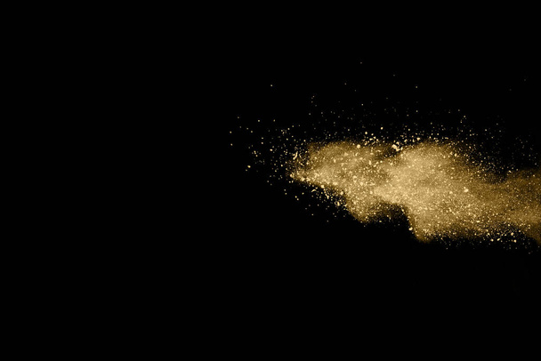 Goldene Pulverexplosion auf schwarzem Hintergrund. Farbige Wolke. Bunter Staub explodiert. Holi bemalen. - Foto, Bild
