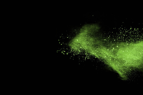 The movement of abstract dust explosion frozen green on black background. Stop the movement of powdered green on black background. Explosive powder green on black background. - Fotoğraf, Görsel