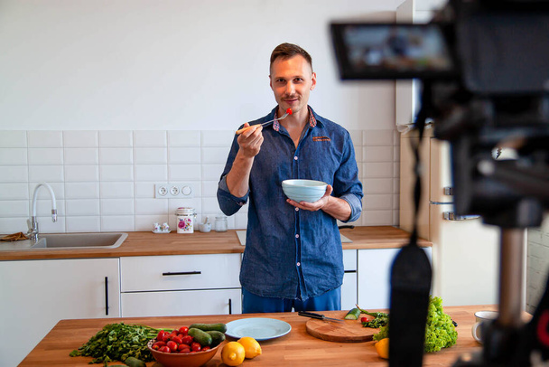Man Blogger En Cocina Moderna Picando Verduras Verdes Frescas Para Grabar Receta de Alimentos
 - Foto, Imagen