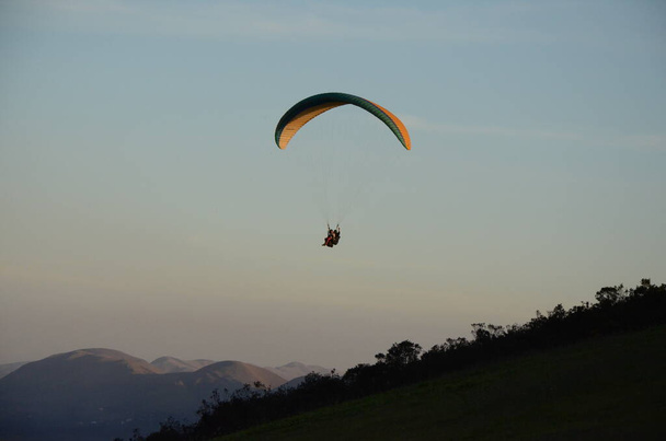 Parapente ao pôr do sol no Topo do Mundo (traduzido para o Topo do Mundo) em Minas Gerais
 - Foto, Imagem