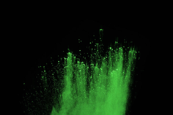 The movement of abstract dust explosion frozen green on black background. Stop the movement of powdered green on black background. Explosive powder green on black background. - Foto, Bild