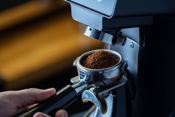 coffee grinder grinding coffee pouring into a portafilter - Zdjęcie, obraz
