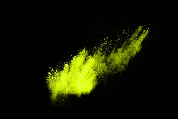 De beweging van abstracte stofexplosie bevroren groen op zwarte achtergrond. Stop de beweging van poedergroen op zwarte achtergrond. Explosief poeder groen op zwarte achtergrond. - Foto, afbeelding