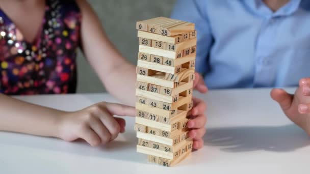 Children play a wooden board game on the table at home. - Video