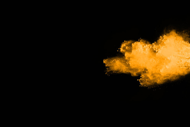 Freeze motion of yellow dust explosion isolated on black background. - Photo, image