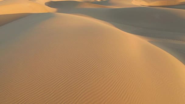 Drone aereo 4K che sorvola magiche onde di dune di sabbia in luce dorata del tramonto - Filmati, video