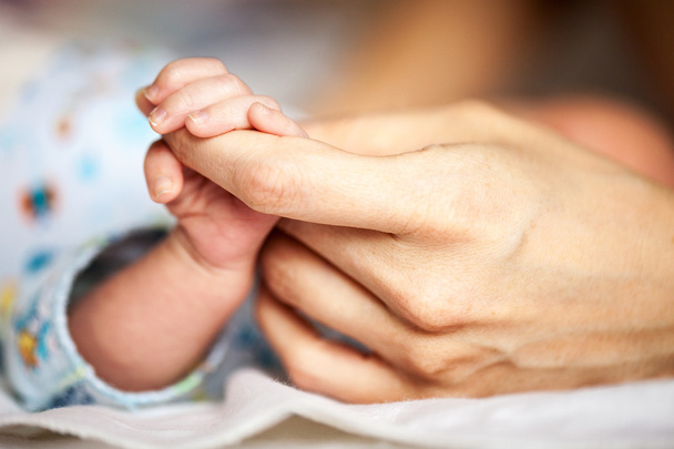 Novorozené dítě držící matku za ruku - Fotografie, Obrázek