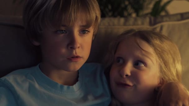 The boy hugged girl and are watching tv. Blond children are discussing cartoon. - Metraje, vídeo