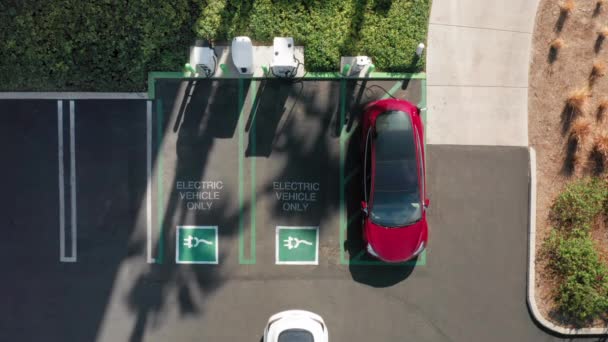 4K bovenaanzicht op elektrische auto parkeren bij het laadstation, USA - Video