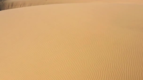 Dron powietrzny 4K lecący nisko nad niesamowitą falową fakturą pustyni piaskowej  - Materiał filmowy, wideo