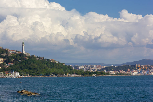 Skyline of Trieste, Italy, and the Vittoria Light seen from Barcola district seafront on an early summer day - Photo, Image