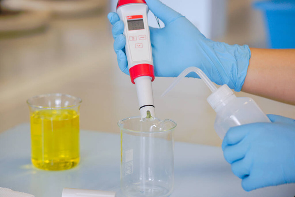 The scientist work at the chemical solution with handle pH meter  - Photo, Image