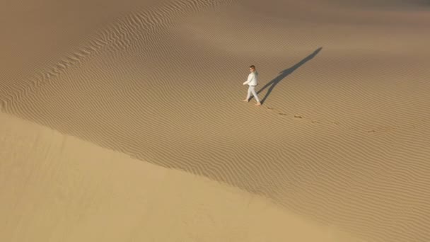 4K slow motion widok z lotu ptaka kobieta przechodząca przez szczyt wydmy, USA natura - Materiał filmowy, wideo
