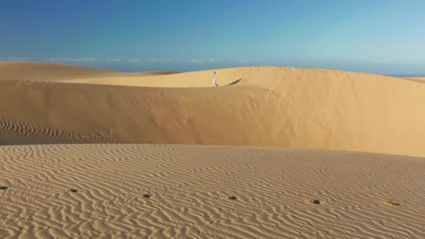 4K cámara lenta de la mujer en ropa deportiva caminando por dunas de arena
 - Imágenes, Vídeo