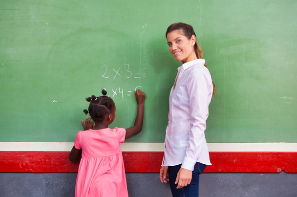 School teacher interviewing pupil at chalkboard. Back to school concept.. - Photo, Image
