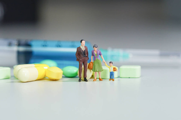 Miniatuur mensen - Het gezin met Medicijn pillen                                - Foto, afbeelding