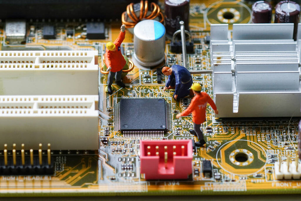 Technicy naprawiają centralny procesor (CPU) na płycie głównej komputera. Miniaturowi ludzie - Zdjęcie, obraz
