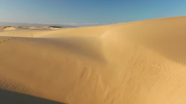 Nazik gündoğumu ışığında sihirli dalgalı kum tepeleri, 4K hava manzaralı İHA uçuşu - Video, Çekim