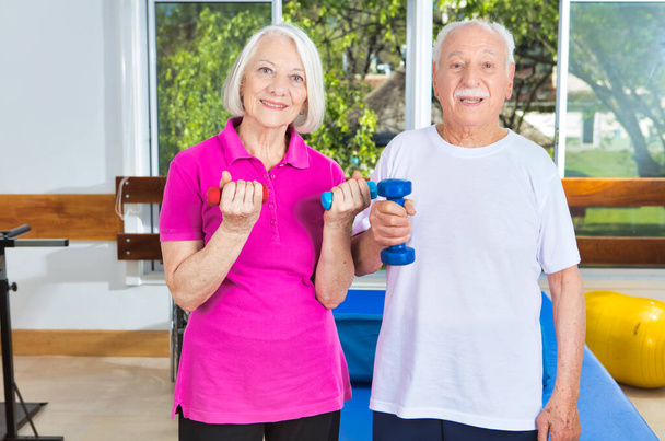 Ηλικιωμένοι στο γυμναστήριο κάνοντας σωματικές ασκήσεις. - Φωτογραφία, εικόνα
