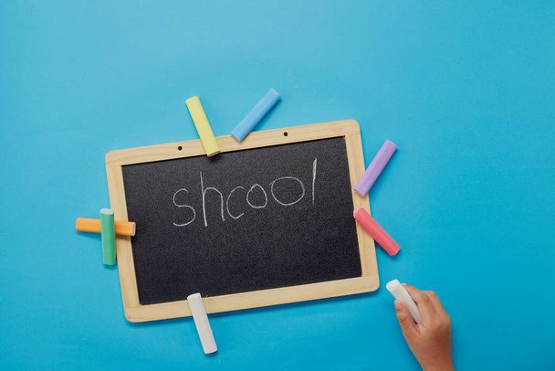 High angle view of girl writing on a blackboard. Back to school concept. - Фото, зображення