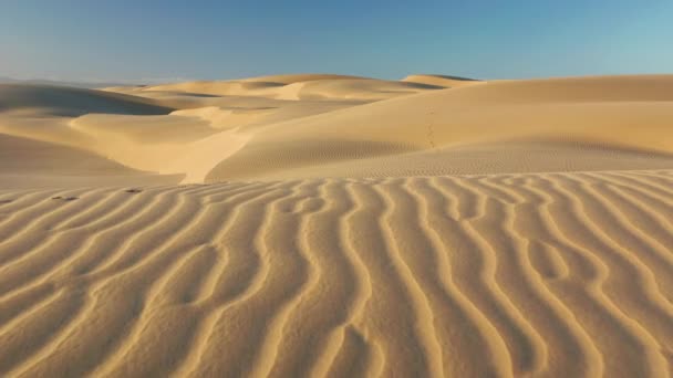 Misteriosas dunas de arena ondulada en suave luz del amanecer, vuelo de drones con vista aérea 4K
 - Metraje, vídeo
