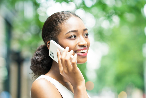 Młoda kobieta biznesu dzwoni poprzez umieszczenie smartfona na uchu - Zdjęcie, obraz