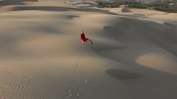 Vista aérea 4K de la mujer caminando por dunas de arena en la naturaleza del desierto
 - Metraje, vídeo