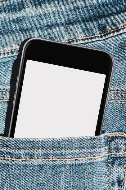 Telefone celular com tela de mockup em branco no bolso de jeans azuis
 - Foto, Imagem