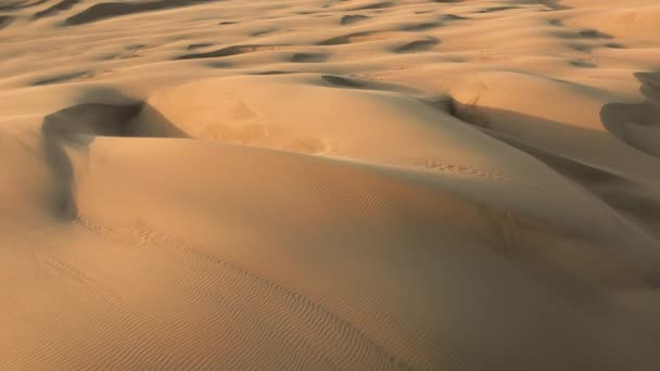 4K vista aerea drone volare da belle dune di sabbia ondulata in luce dorata del tramonto - Filmati, video
