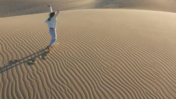 4K slow motion widok z powietrza kobiety biegnącej przez wydmę, USA pustynna przyroda - Materiał filmowy, wideo