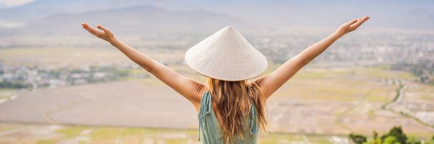 Young woman tourist in a traditional Vietnamese hat travels to Vietnam BANNER, LONG FORMAT - Fotografie, Obrázek