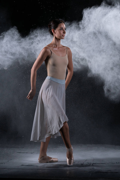 ballerina dancing in the studio near the black wall - Фото, зображення