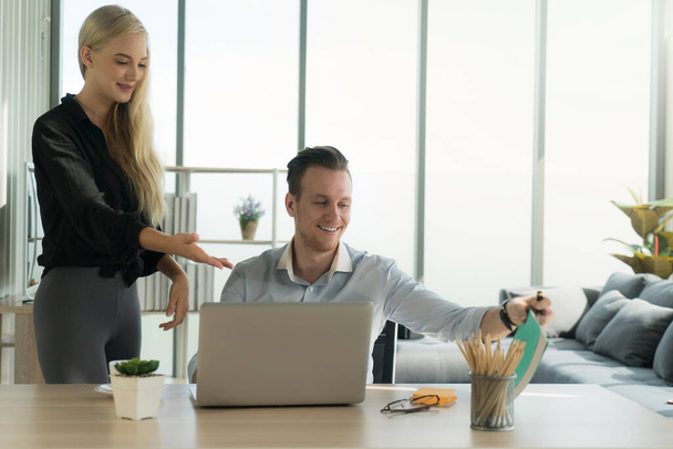 businessman and businesswoman in casual look staying together at home and working on laptop notebook computer with relax and happiness smile face. working at home concept. - Foto, imagen