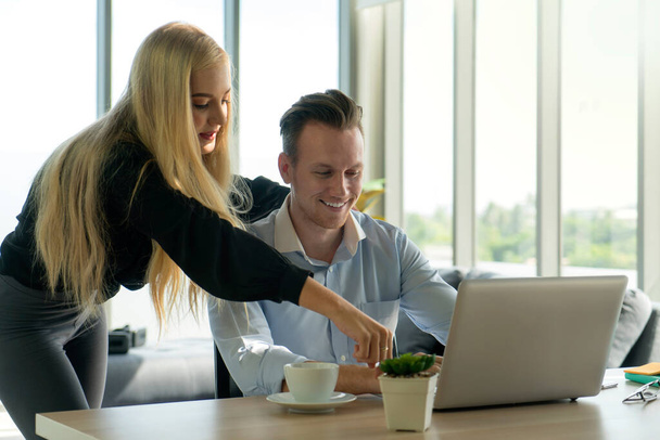 businessman and businesswoman in casual look staying together at home and working on laptop notebook computer with relax and happiness smile face. working at home concept. - Photo, Image