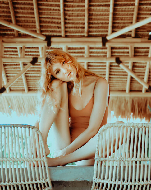 Sexy redhead model in swimsuit posing in Bali during her vacation, Vogue Style in warm colors. Red haired woman with Charming Appearance - Foto, Imagen