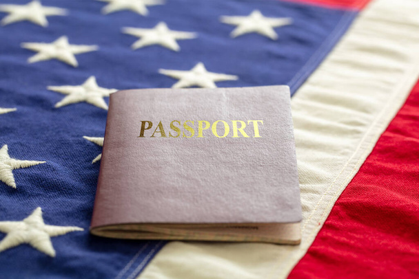 Διαβατήριο με φόντο τη σημαία των ΗΠΑ, κοντινή προβολή. Μετανάστευση, Ηνωμένες Πολιτείες της Αμερικής - Φωτογραφία, εικόνα