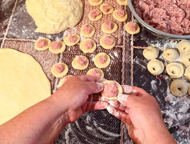 Bereiding van een culinair traditioneel meel van meel en gehakt vlees, knoedels / ravioli. - Foto, afbeelding