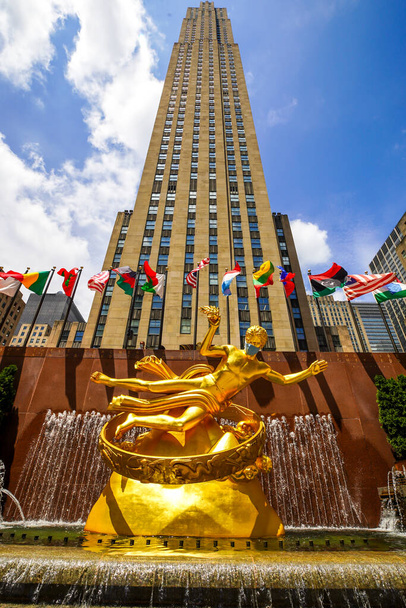 NEW YORK CITY - JULY 16, 2020: Statue of Prometheus with face mask at the Lower Plaza of Rockefeller Center in Midtown Manhattan during Coronavirus pandemic in New York - Foto, Imagem