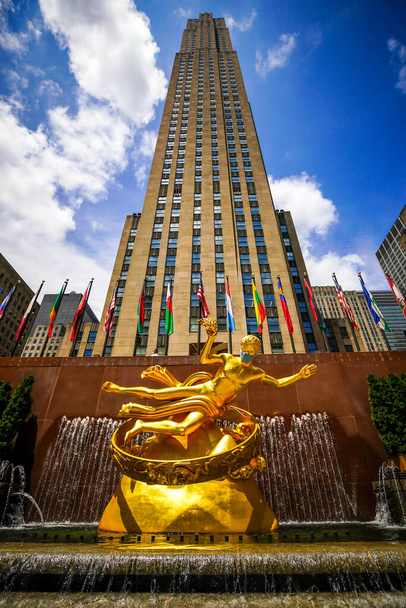 NEW YORK CITY - JULY 16, 2020: Statue of Prometheus with face mask at the Lower Plaza of Rockefeller Center in Midtown Manhattan during Coronavirus pandemic in New York - Foto, Imagem