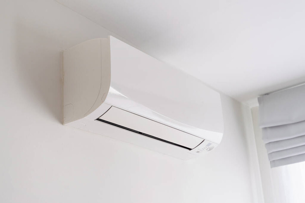 Air conditioner on white concrete wall in area of room space. - Фото, изображение