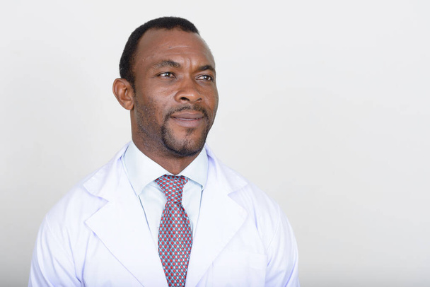 Studio shot of handsome bearded African man doctor against white background - Photo, image