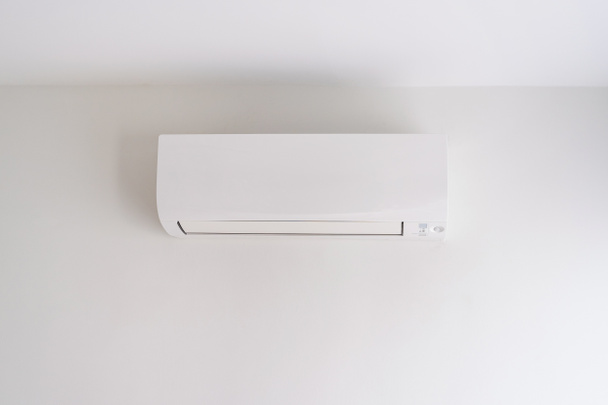 Air conditioner on white concrete wall in area of bedroom space. - Фото, изображение