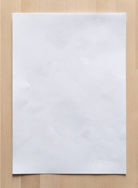 White paper sheet on wood for business background. Close up image. - Фото, зображення